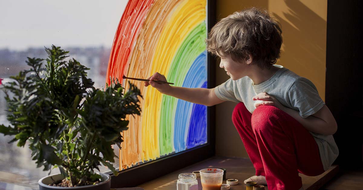 Young boy painting a rainbow