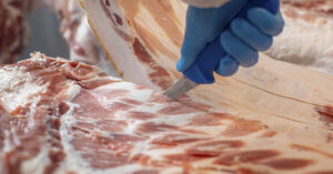 Pork being cut in factory setting