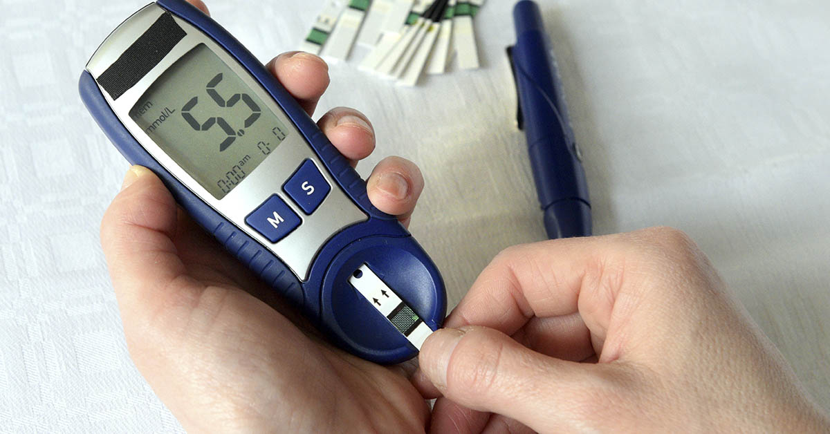 person using blood glucose monitor