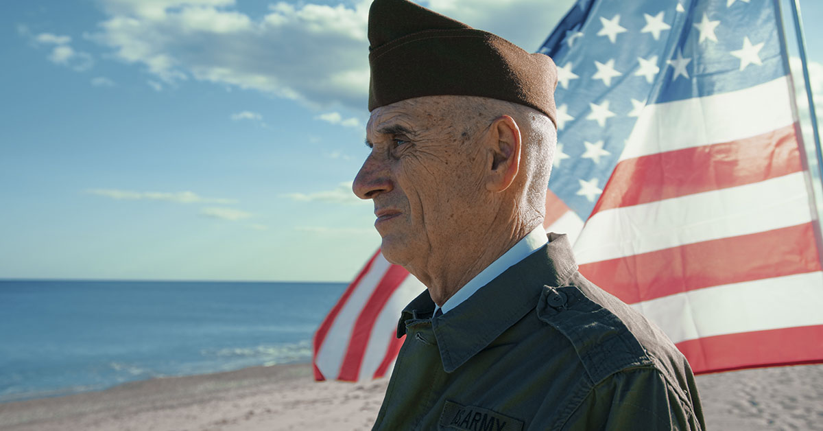 US Veteran standing in front of an American Flag