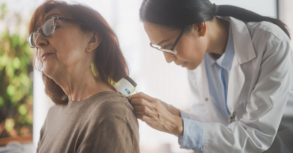 Women getting mole on skin checked by doctor. Skin cancer screening concept