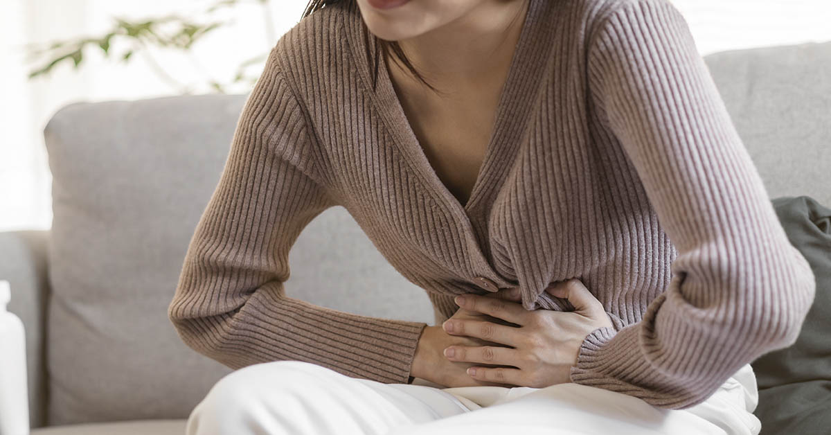 woman holding her stomach in pain. Stomach cancer symptom concept