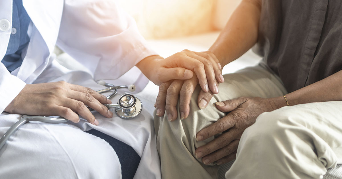 Doctor consoling patient putting hand on theirs