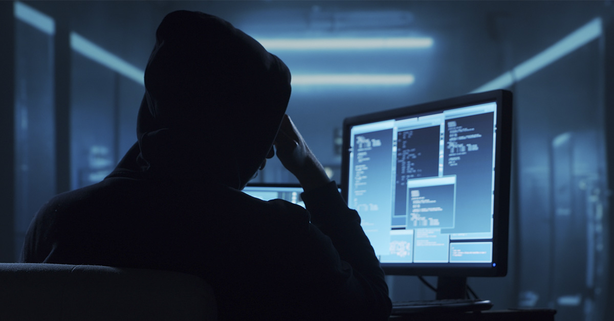 Silouhette of a man siting in front of computer. Dark anonymous, dark web, hacker concept
