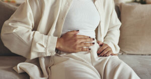 Endometriosis Diagnosis Transformed by Game-Changing New Guidelines woman holding her abdomen in discomfort. Endometriosis concept