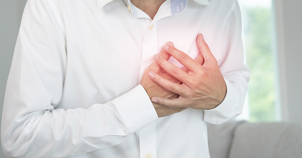 person placing hand over chest in pain. heart attack symptom concept