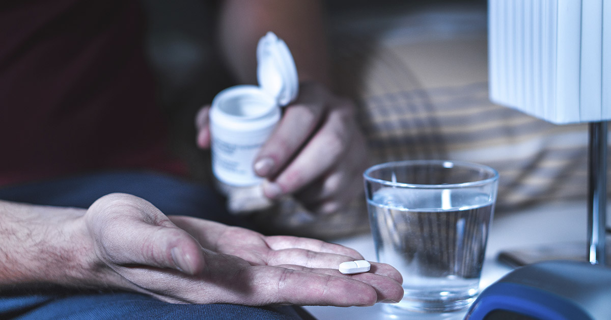 person taking medication, dispensing from white plastic bottle into hand