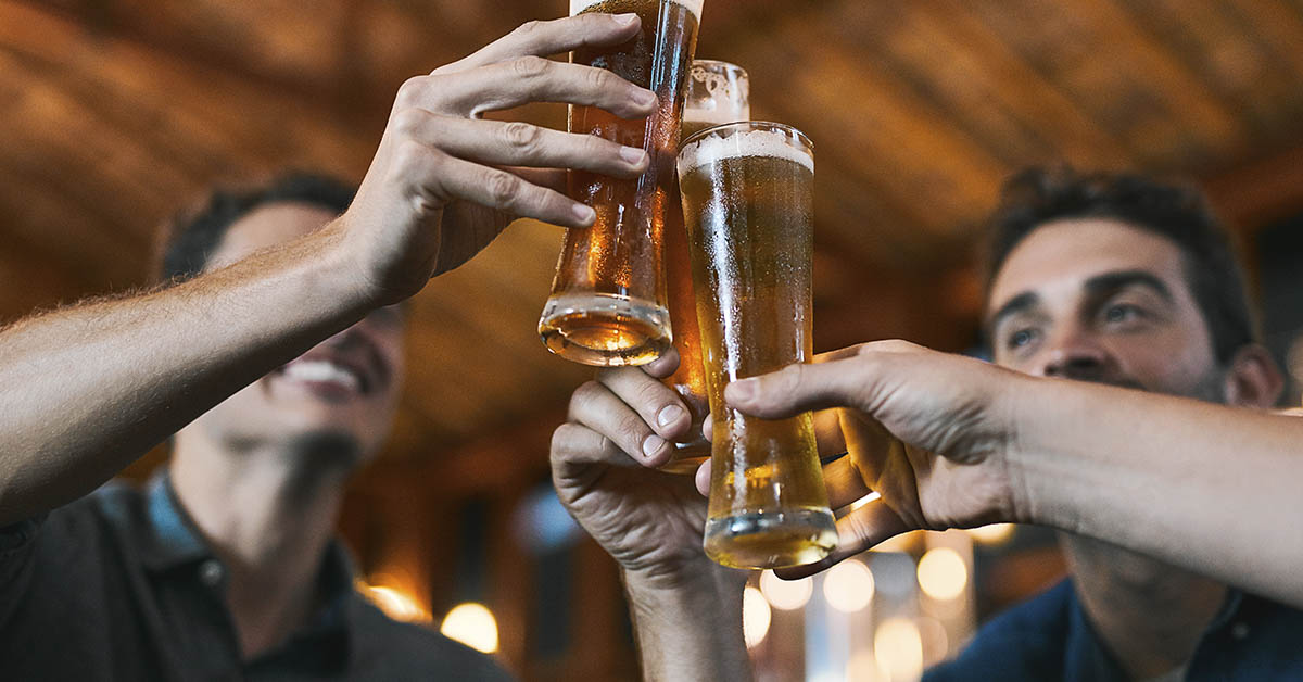 people raising their glasses while drinking beer