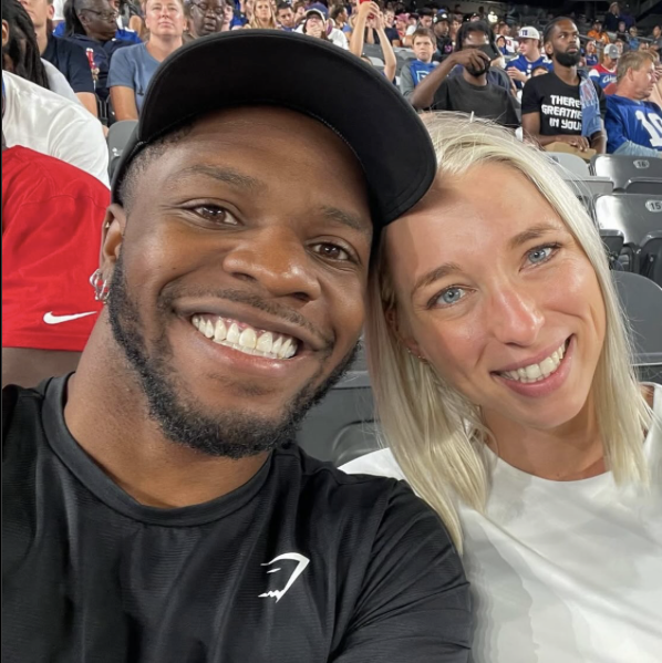Charles and Sydney Rogers smiling together at what appears to be a sporting event.