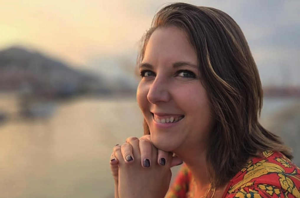 Brianna Lafferty, who experienced a near-death experience, smiling by the water at sunset.