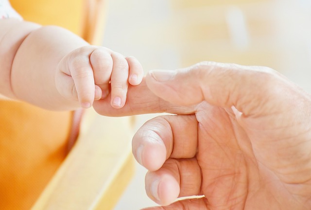 baby holding adult finger