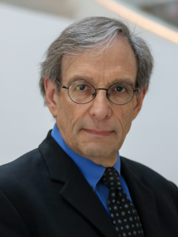 Professor James Alan Fox, a Northeastern University criminologist with gray hair and glasses wearing a dark suit and blue shirt with patterned tie. Fox oversees the Mass Killing Database and disputes claims of a New England serial killer, noting the evidence doesn't align with known serial murder patterns.