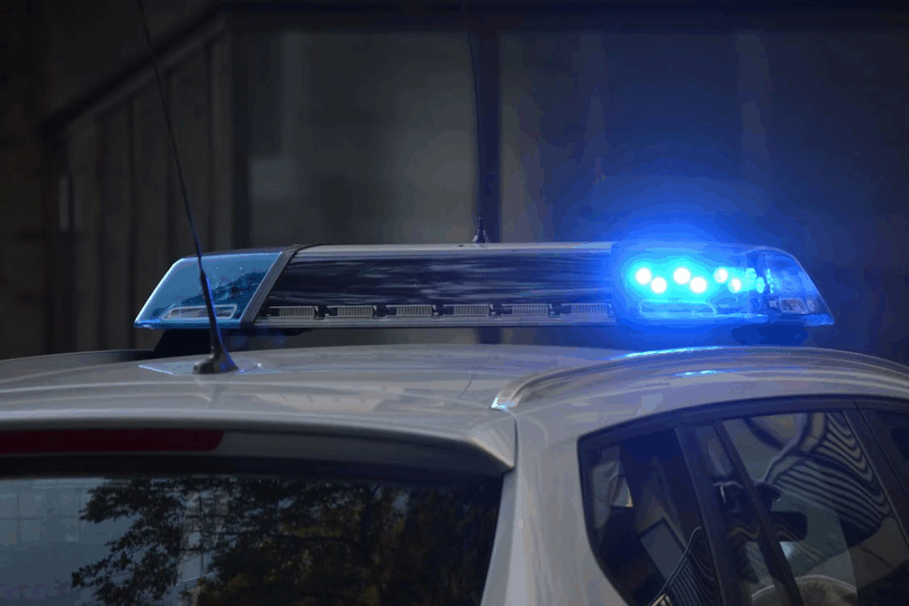 Police vehicle light bar illuminated with blue lights in darkness, representing law enforcement's role in addressing property disputes, though as Velazquez discovered, police are often limited in their ability to immediately remove occupants.