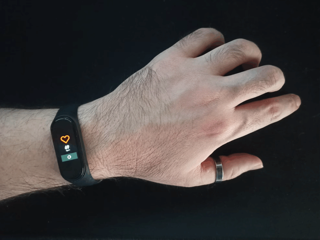 Close-up of a fitness tracker on someone's wrist displaying a heart icon, illustrating how walking creates an amazing chain reaction that improves heart rate and circulation for better cardiovascular health.