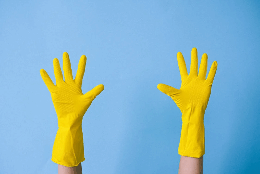 Crop unrecognizable person in rubber gloves raising arms