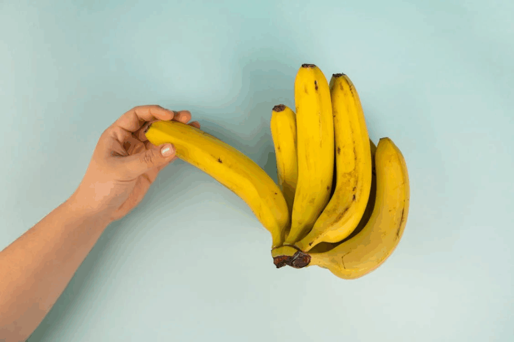 Crop person with bunch of tasty fresh bananas