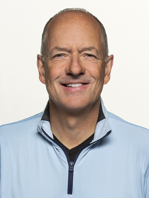 Andrew Witty smiling in light blue jacket, the UnitedHealthcare executive who stepped down citing "personal reasons" following the corporate crisis and public backlash.