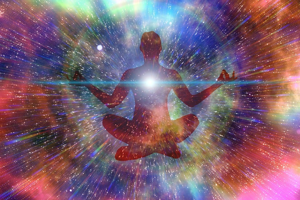 Person meditating with bright cosmic energy around them, representing the otherworldly realm described in near-death experience.