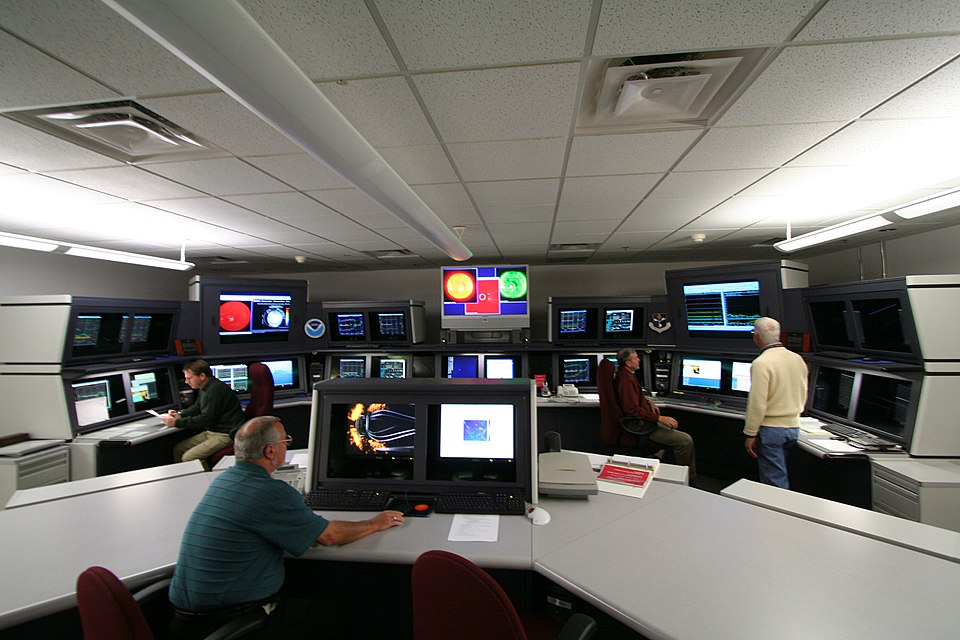 NOAA Space Weather Prediction Center monitoring room where scientists track solar activity and geomagnetic storms.