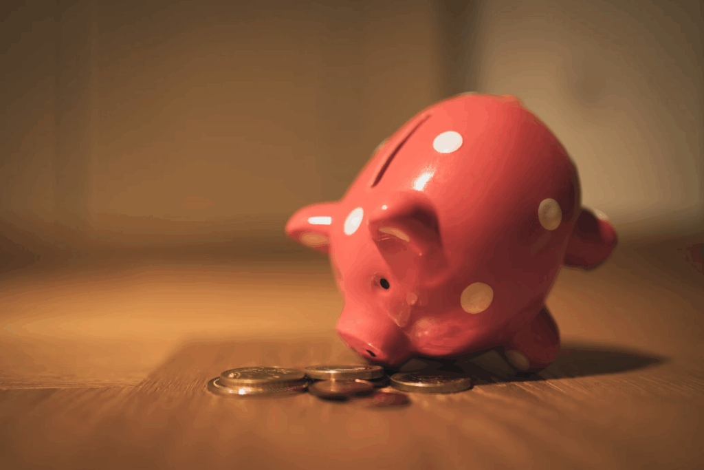 Piggy bank with scattered coins representing high costs of cosmetic treatments for medication side effects.