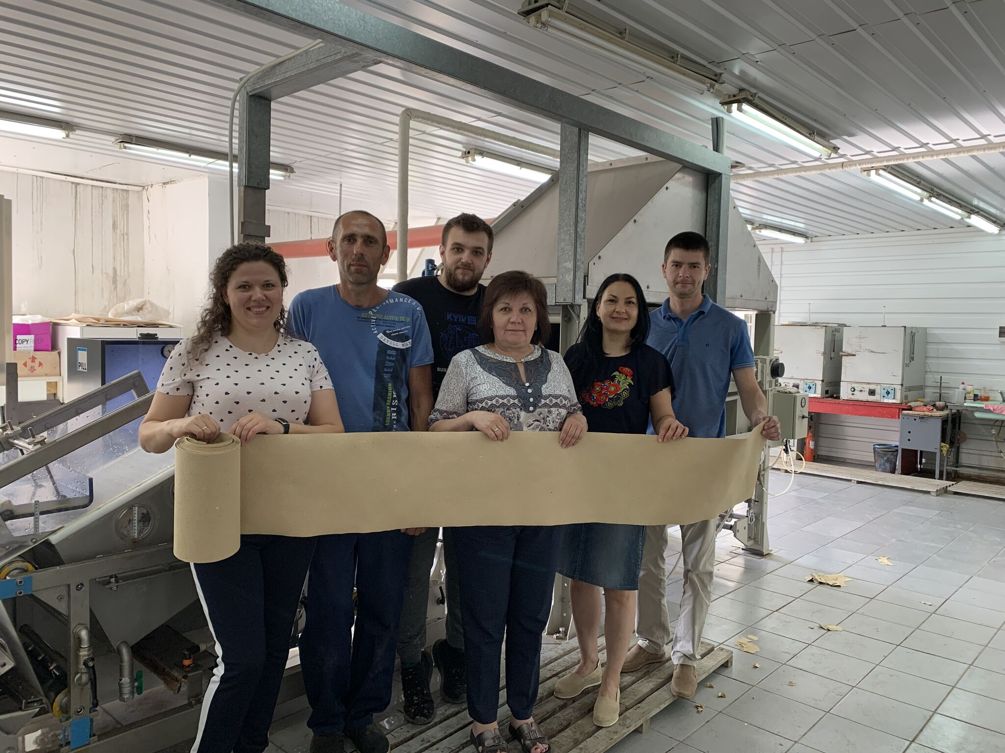 Valentyn Frechka and Releaf Paper team holding up there products made by turning leaves into paper.