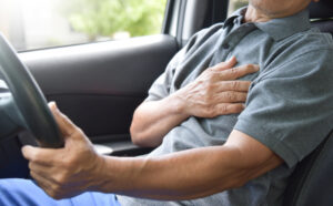 Asian,Elderly,Male,Having,Heart,Attack,While,Driving,A,Car.