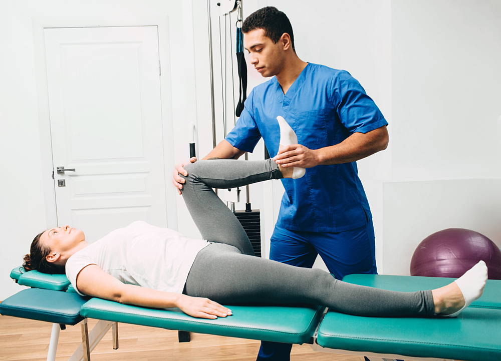 physiotherapist doing leg muscle stretching to the patient. Treatment of a woman's sciatic nerve