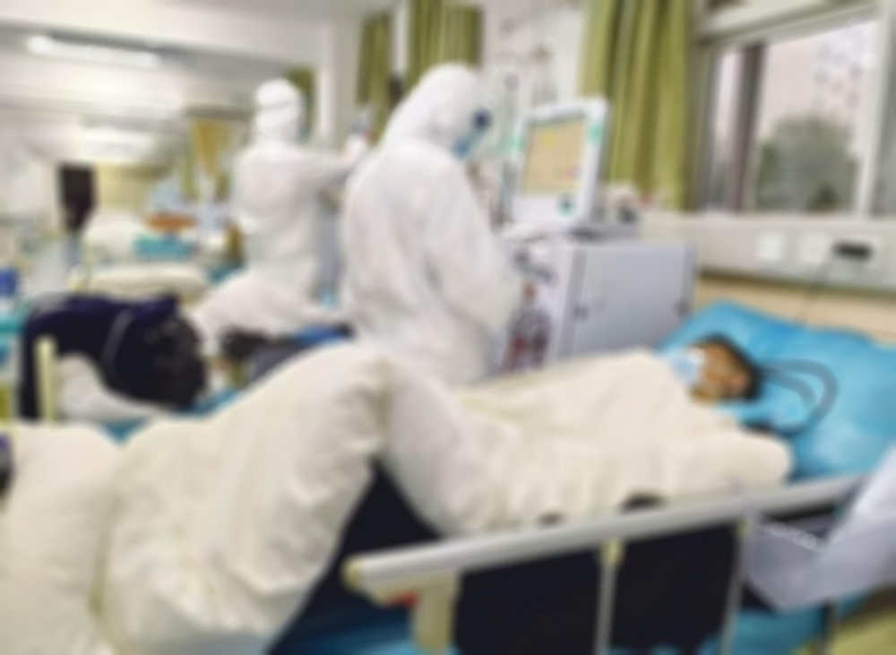 Paramedics working to isolated corona virus suspect in blurry view. viruses that include the common cold, and viruses such as SARS and MERS. This new virus was named "COVID - 19"