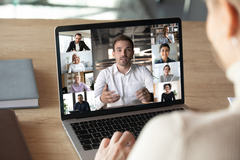 Close up of woman worker talk brainstorm on video call on computer with diverse colleagues, have online team briefing together, female employee engaged in webcam conference on laptop with coworkers