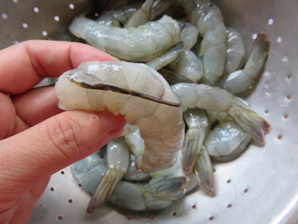Using the knife to make a slit at a backside of the shrimp to remove the little vein or black line before cooking, shrimp can be used for a variety of dishes such as salads, scampi and ka-bobs