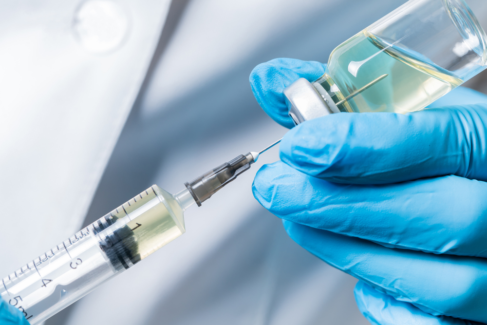 liquid drug or vaccine for treatment, flu in the hand of the doctor close-up