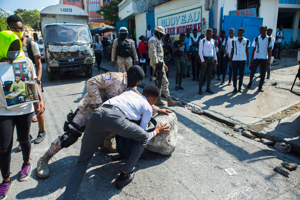 a student helps the police to unblock the street during a demonstration against the kidnapping in Haiti, Port-au-Prince, Jan 21, 2021 (Photo Odelyn Joseph)