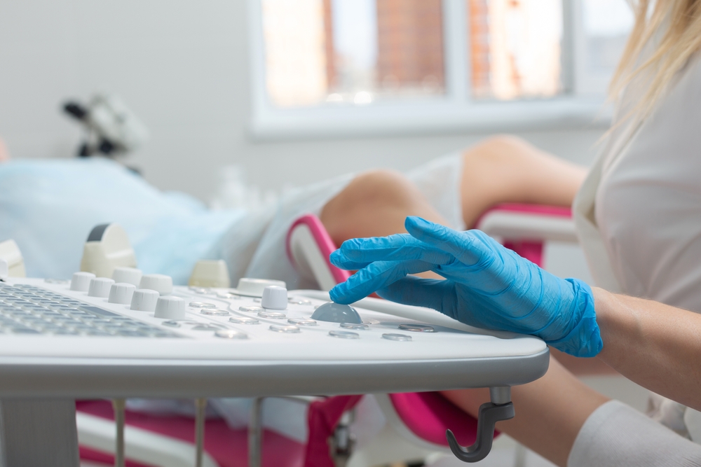 A gynecologist performs an ultrasound diagnostic procedure for a girl lying in a gynecological chair. Pregnancy management, fetal health monitoring
