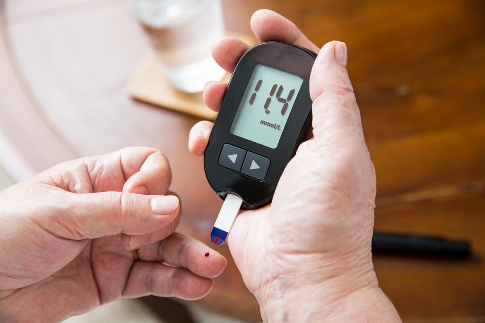 Senior woman checking blood sugar level using home glucometer. Close-up hand of old person with diabetes. Diabetes treatment for elderly people.