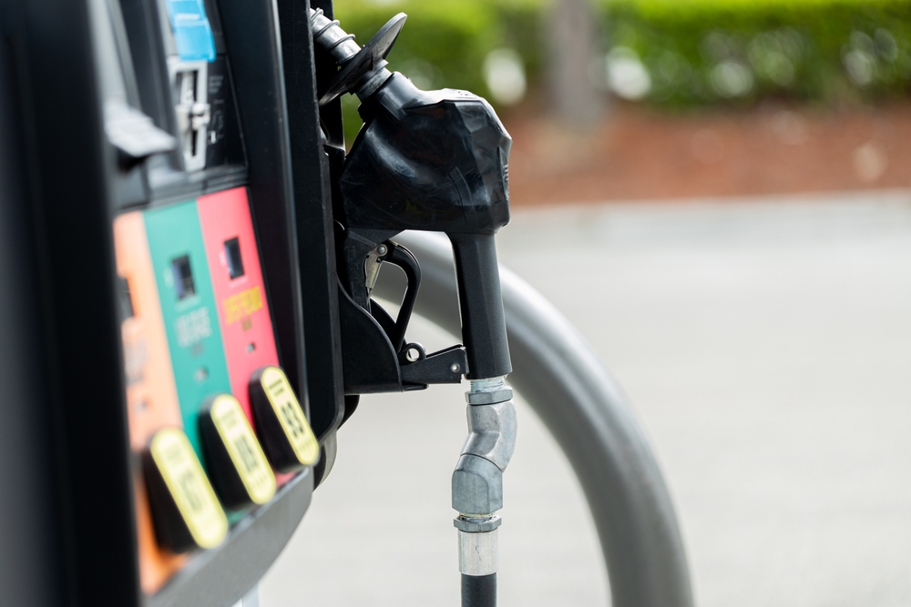 Gas pump at an American gas station with a black nozzle and colorful fuel option buttons oil petrol gasoline