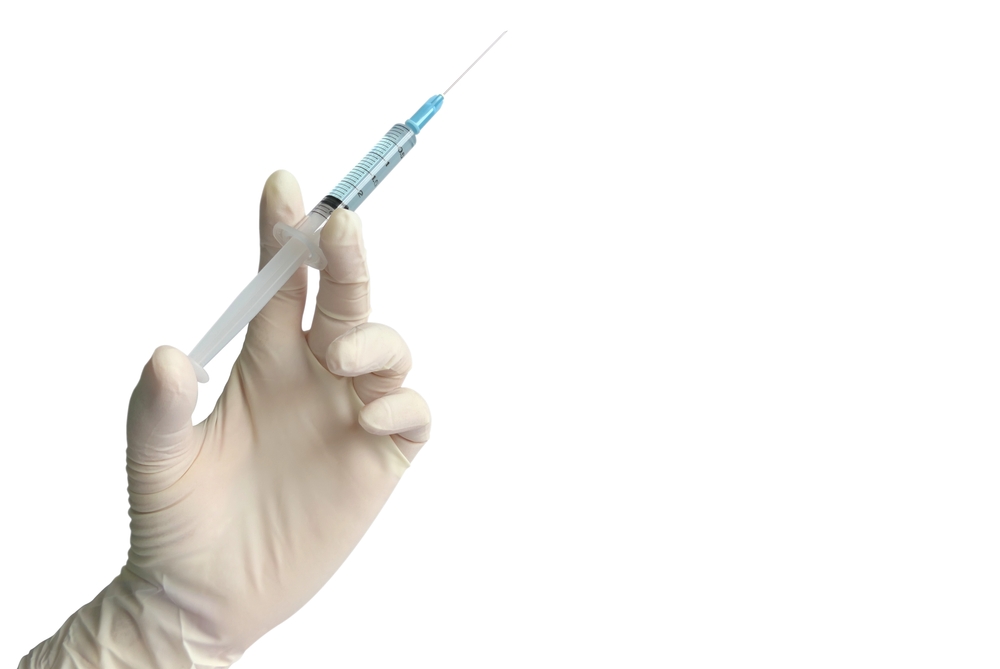 Close up doctor's hand in glove holding  syringe with needle isolated on white background with copy space for medical treatment, vaccination, filler injection, cosmetic surgical, laboratory concept.