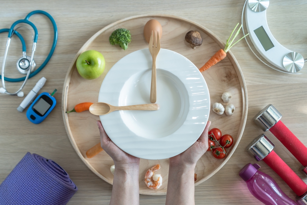 Intermittent fasting IF diet concept with hour clock timer for skipping meal, eating keto low carb food meal healthy nutritional with gym exercise for weight loss, cholesterol and diabetic control