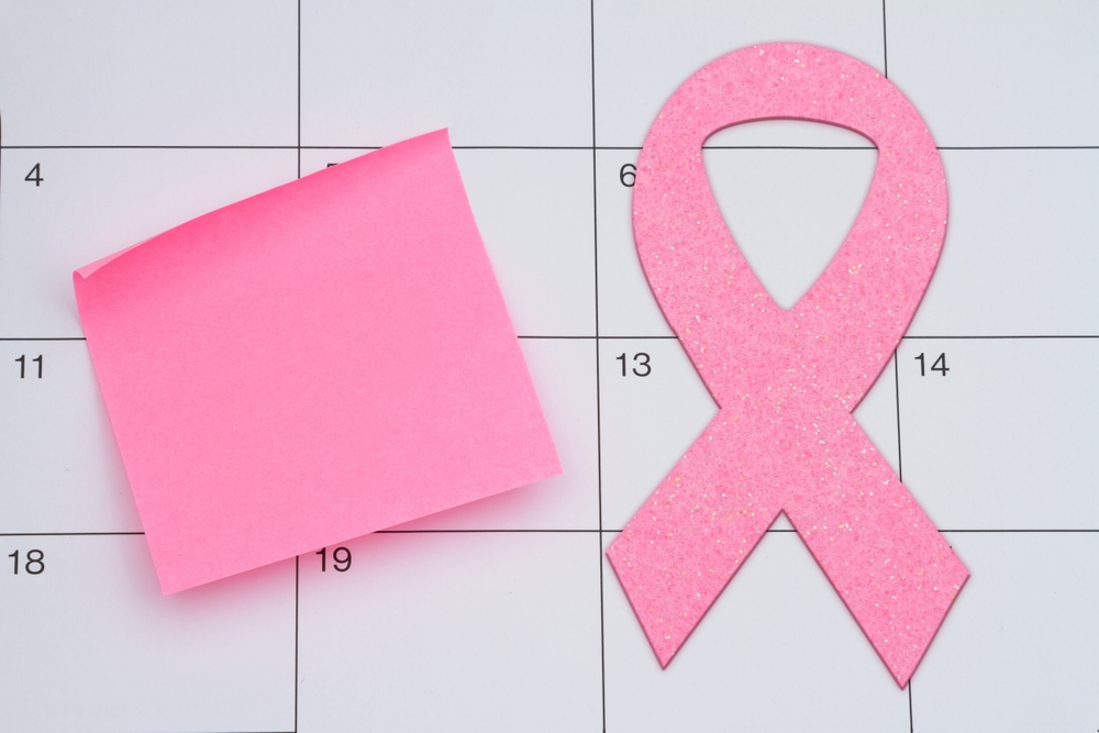 Time for your mammogram checkup with pink ribbon and sticky note on a calendar