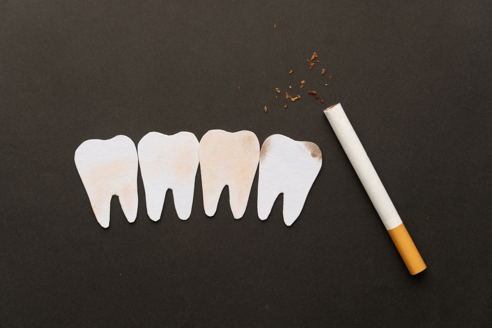 Cigarettes or tobacco with tooth shape on black background. Teeth problems caused by smoking include staining, gum disease and cavities. World no tobacco day concept template.
