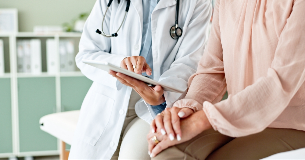 Clinic, tablet and hands of doctor with patient for consulting, medical service and help in hospital. Healthcare, telehealth and people on digital tech for diagnosis, online results and insurance