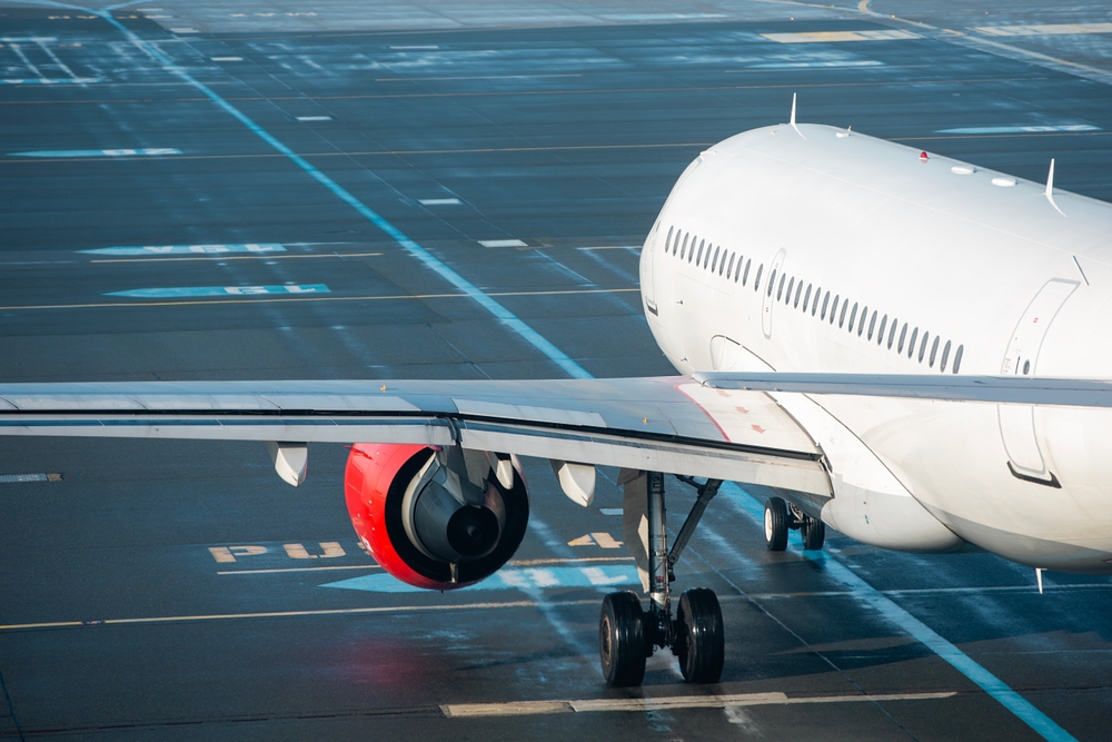 Commercial airplane during taxiing on taxiway to airport runway for take off on sunny day.
