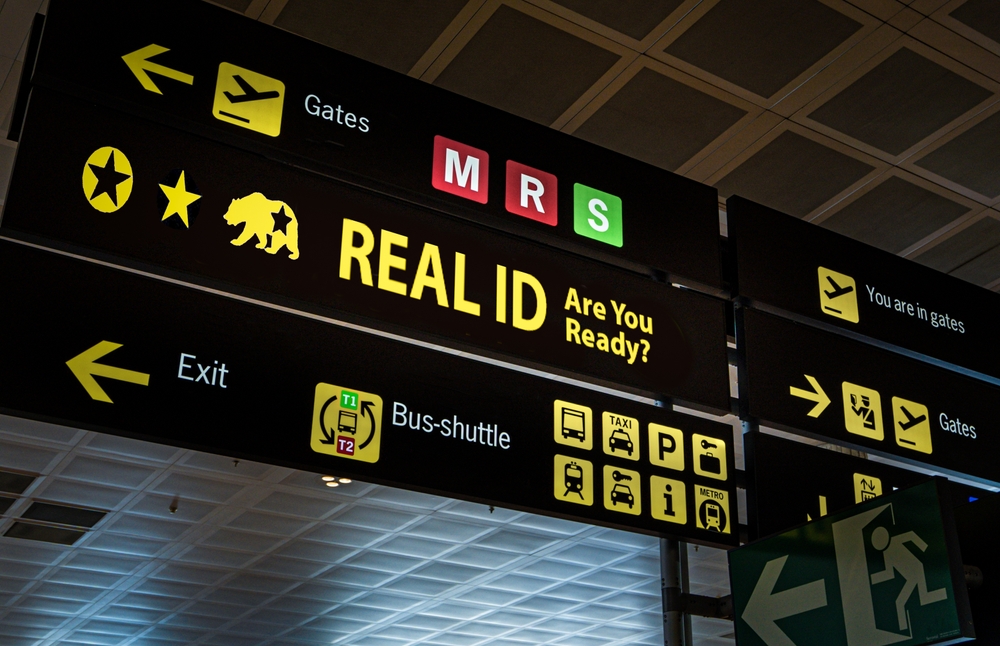 Illuminated airport signage displaying the Real ID compliance, reminding passengers at airport of new travel document requirements.
