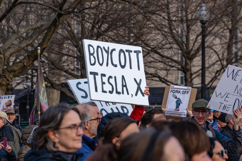 Boston, MA, US-March 4, 2025: Anti-Trump protest in Boston Common organized by the 50501 Movement entitled 'Saving Our Union' with sign reading Boycott Tesla and X.