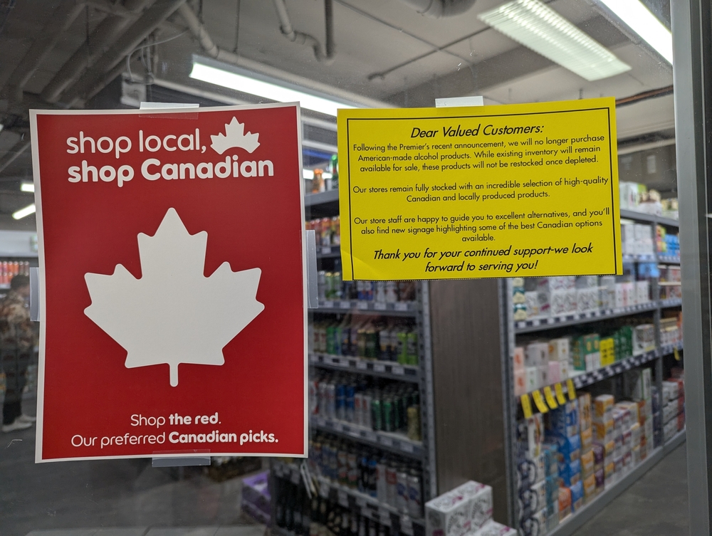 Banff, Canada- March 17 2025: Shop Canadian signs Alberta liquor store after premier's decision to stop selling American Alcohol amid trade war with USA. Buy local, maple leaf symbol, national boycott