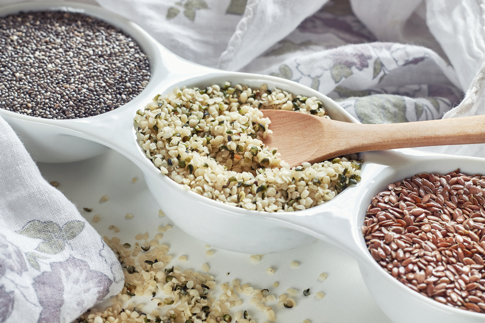 Hemp, flax and chia seeds in bowl on white background. Vegan sources of Omega-3