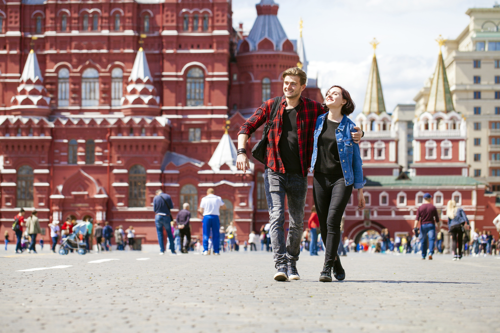 Happy tourists sightseeing city with map. Red Square, Moscow, Russia