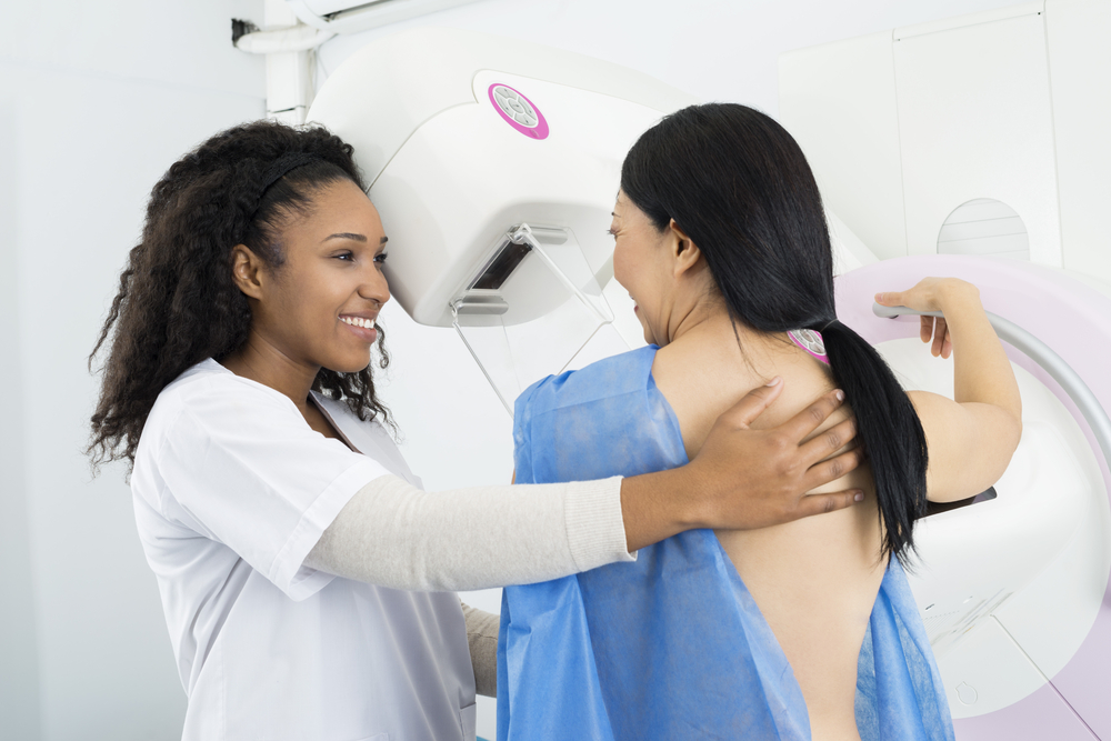 Happy Doctor Assisting Woman Undergoing Mammogram X-ray Test
