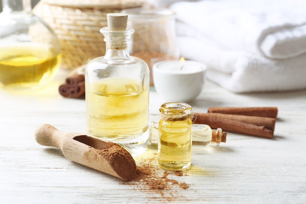 Composition with bottles of cinnamon oil on wooden background