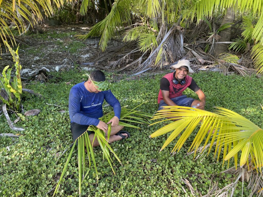 Men on the island making palm baskets