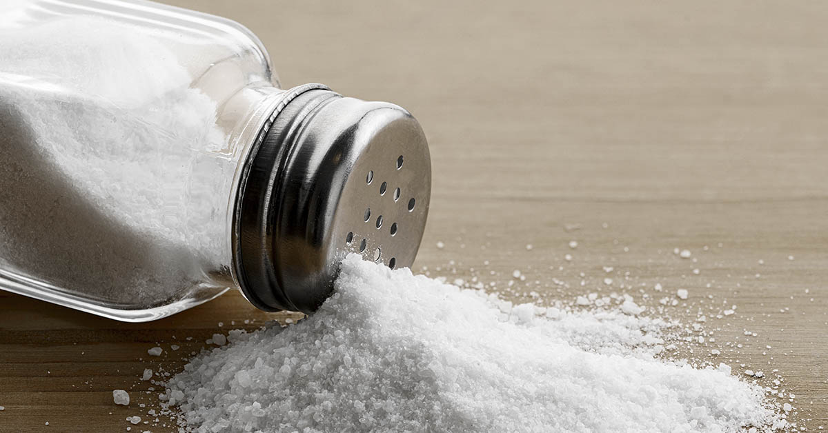 salt shaker tipped over with salt spilling out
